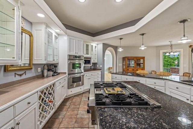 N66W38493 N Woodlake Cir, Oconomowoc, WI 53066 - kitchen featuring appliances with stainless steel finishes, white cabinets, glass insert cabinets, hanging light fixtures, and recessed lighting