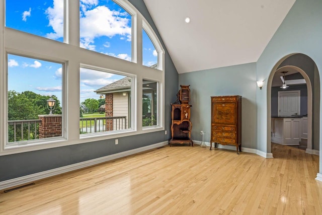 N66W38493 N Woodlake Cir, Oconomowoc, WI 53066 - unfurnished room featuring wood finished floors, arched walkways, and high vaulted ceiling