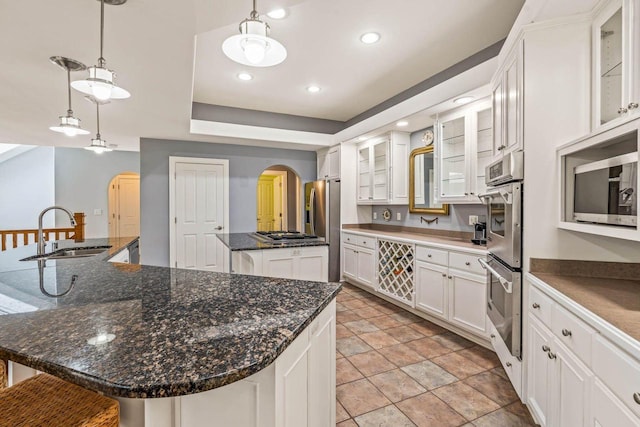 N66W38493 N Woodlake Cir, Oconomowoc, WI 53066 - kitchen with arched walkways, a large island, stainless steel appliances, white cabinets, and recessed lighting