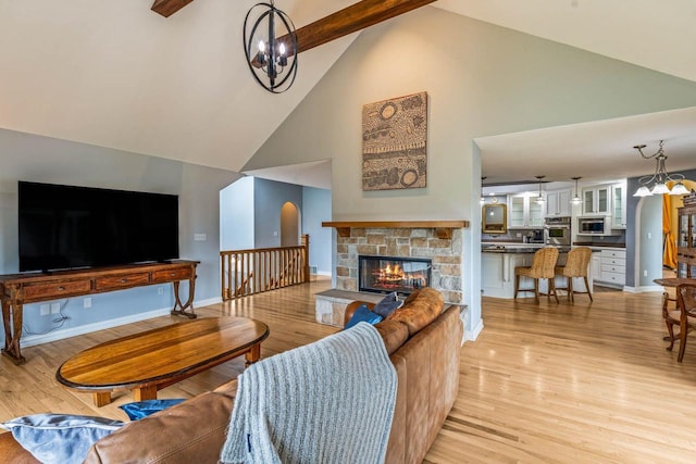 N66W38493 N Woodlake Cir, Oconomowoc, WI 53066 - living area featuring a chandelier, high vaulted ceiling, light wood-type flooring, a fireplace, and beam ceiling