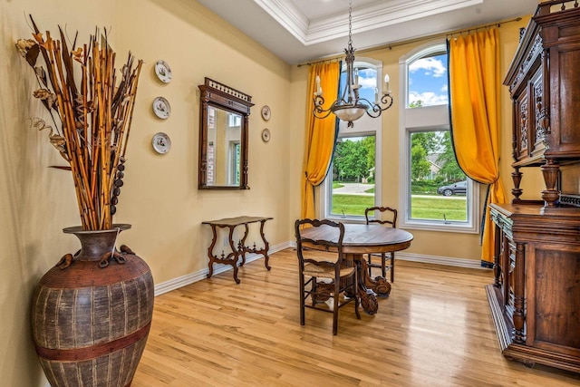 N66W38493 N Woodlake Cir, Oconomowoc, WI 53066 - dining space with a chandelier, light wood-style flooring, a tray ceiling, and ornamental molding