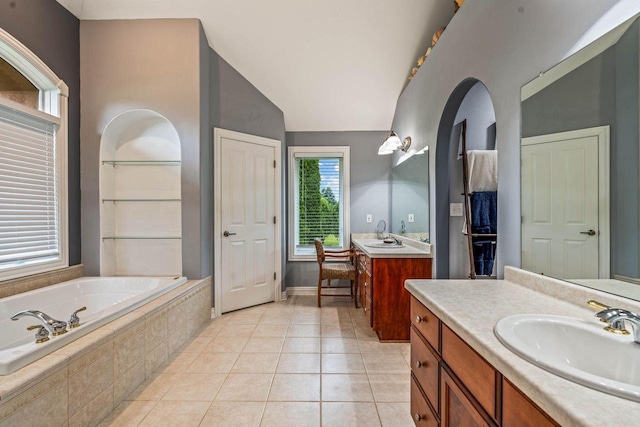 N66W38493 N Woodlake Cir, Oconomowoc, WI 53066 - full bathroom featuring two vanities, a bath, vaulted ceiling, and tile patterned flooring
