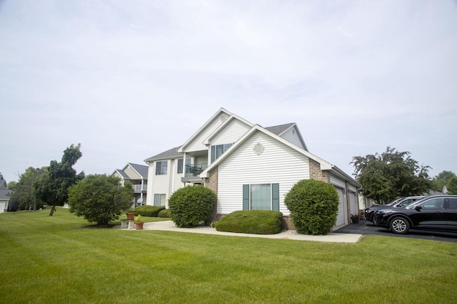 156 Pheasant Run Unit D-4, Johnson Creek, WI 53038 - view of side of property featuring a lawn, a garage, and brick siding