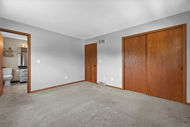 2332 Hughes Ln, Waukesha, WI 53188 - unfurnished bedroom with light carpet, ensuite bathroom, and two closets