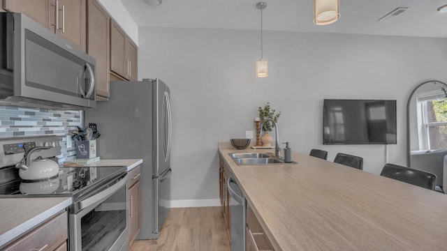 814 N 15th St Unit B, Sheboygan, WI 53081 - kitchen with appliances with stainless steel finishes, light wood finished floors, light countertops, a kitchen breakfast bar, and decorative light fixtures