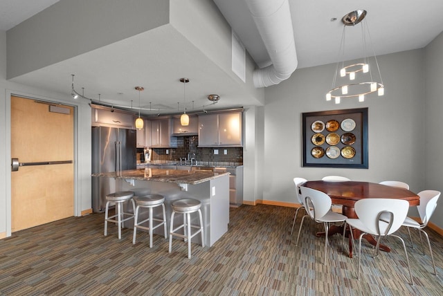106 W Seeboth St Unit 702, Milwaukee, WI 53204 - kitchen with high end fridge, decorative backsplash, a kitchen island, a kitchen bar, and dark stone countertops