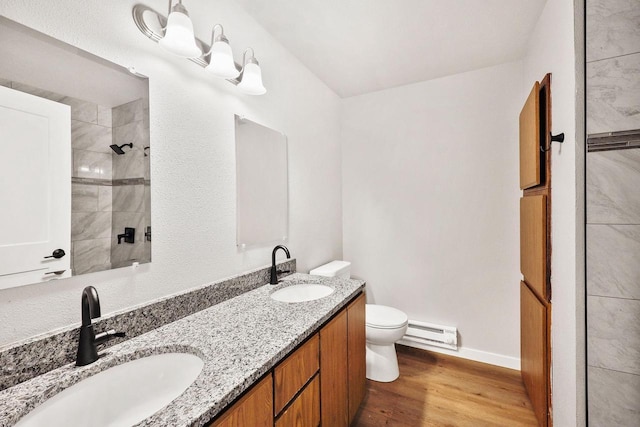 1508 Whispering Pines Way, Fitchburg, WI 53713 - bathroom featuring double vanity, a baseboard radiator, wood finished floors, and a tile shower