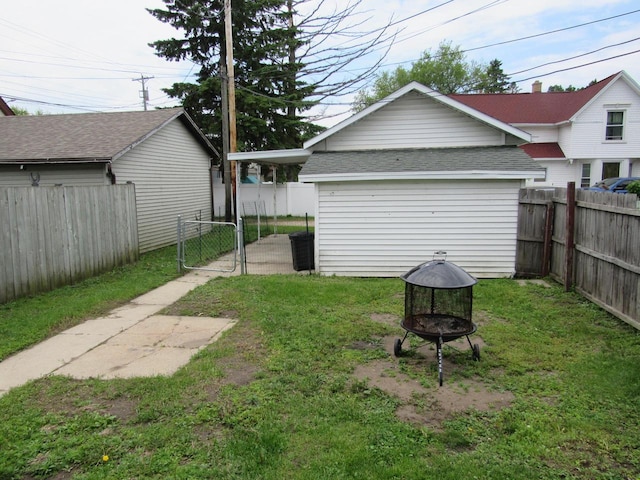 1326 N 11th St, Sheboygan, WI 53081 - fenced backyard featuring a gate, an outdoor fire pit, and an outbuilding