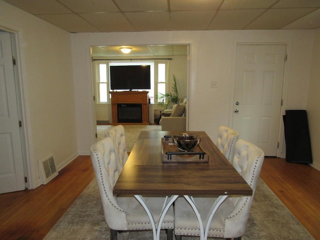 1326 N 11th St, Sheboygan, WI 53081 - dining area featuring wood finished floors, a fireplace, and a drop ceiling