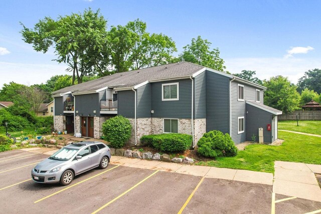 807 Whispering Pines Way, Fitchburg, WI 53713 - view of property featuring uncovered parking, a front yard, brick siding, and a balcony