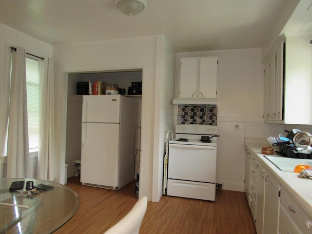 1744 N 27th St, Sheboygan, WI 53081 - kitchen with white appliances, light wood-type flooring, white cabinetry, light countertops, and under cabinet range hood