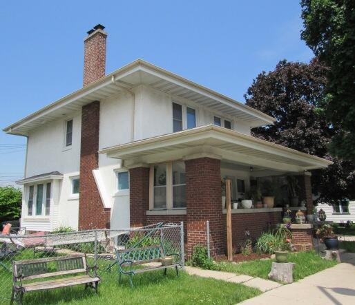 616 N 14th St, Sheboygan, WI 53081 - view of front facade featuring a chimney, stucco siding, covered porch, and brick siding