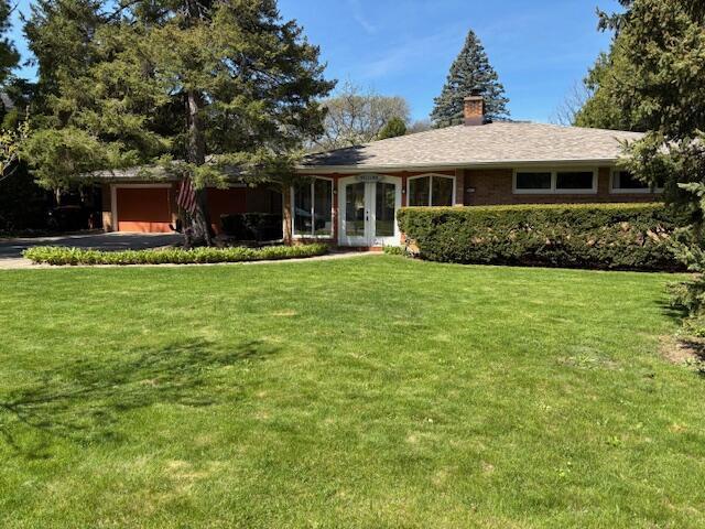 3415 N 105th St, Wauwatosa, WI 53222 - single story home featuring french doors, an attached garage, a front lawn, a chimney, and driveway