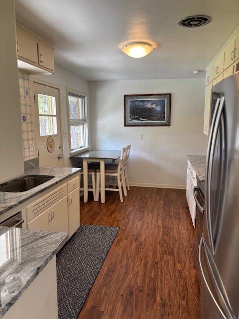 3415 N 105th St, Wauwatosa, WI 53222 - kitchen with freestanding refrigerator, dark wood-style flooring, and light stone counters
