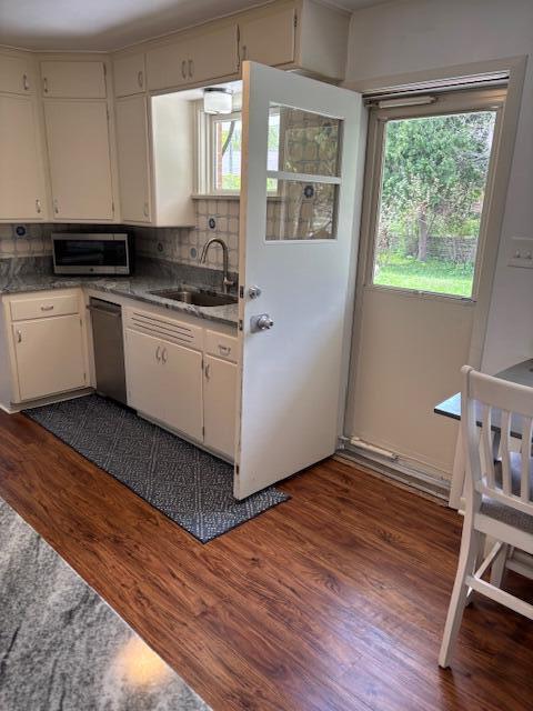 3415 N 105th St, Wauwatosa, WI 53222 - kitchen with stainless steel appliances, dark wood-style flooring, tasteful backsplash, and white cabinets