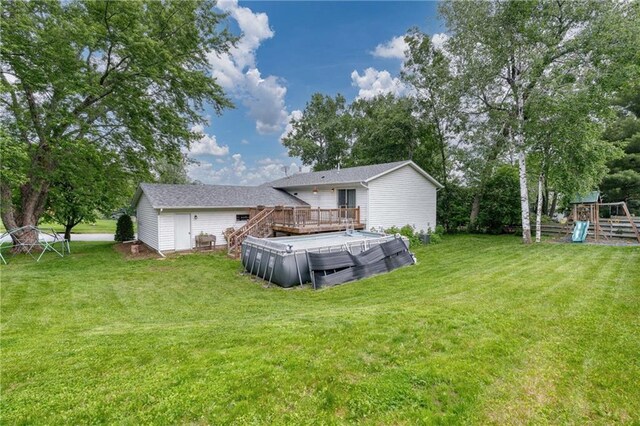 3713 Kingswood Ct, Eau Claire, WI 54701 - back of property with a deck, a playground, and a lawn