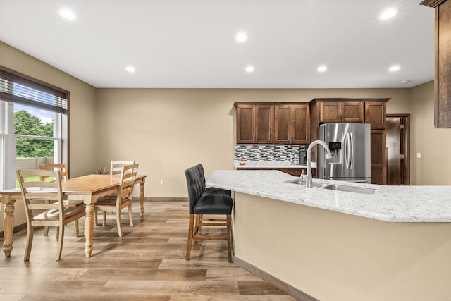 3830 Augusta Ct, Plover, WI 54467 - kitchen with stainless steel fridge, decorative backsplash, recessed lighting, light wood-style flooring, and light stone counters