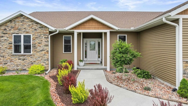 3830 Augusta Ct, Plover, WI 54467 - property entrance featuring stone siding, a shingled roof, and a yard