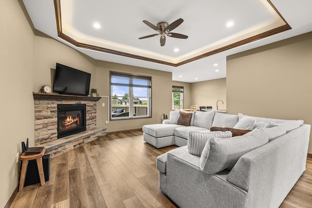 3830 Augusta Ct, Plover, WI 54467 - living room with a tray ceiling, ceiling fan, a fireplace, wood finished floors, and recessed lighting