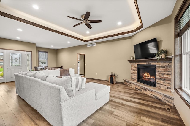 3830 Augusta Ct, Plover, WI 54467 - living room featuring a stone fireplace, wood finished floors, recessed lighting, ceiling fan, and a raised ceiling
