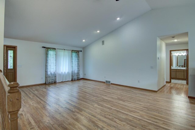 8103 W Folsom St, Eau Claire, WI 54703 - unfurnished living room with lofted ceiling, light wood finished floors, and recessed lighting