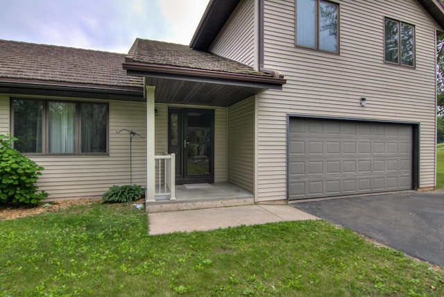 8103 W Folsom St, Eau Claire, WI 54703 - view of front of home featuring an attached garage, asphalt driveway, and a front yard