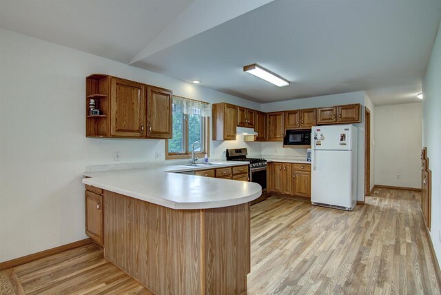 8103 W Folsom St, Eau Claire, WI 54703 - kitchen featuring freestanding refrigerator, stainless steel gas range oven, black microwave, light wood-type flooring, and a peninsula