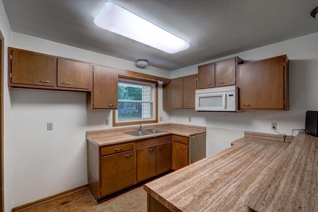 1702 Rae Ln, Madison, WI 53711 - kitchen with white microwave, dishwasher, light countertops, and brown cabinetry