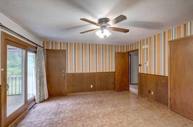 1702 Rae Ln, Madison, WI 53711 - spare room with wainscoting, a ceiling fan, wallpapered walls, and wood walls