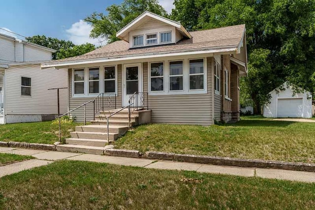 619 Middle St, Beloit, WI 53511 - bungalow-style home with a front lawn, an outbuilding, roof with shingles, and a garage