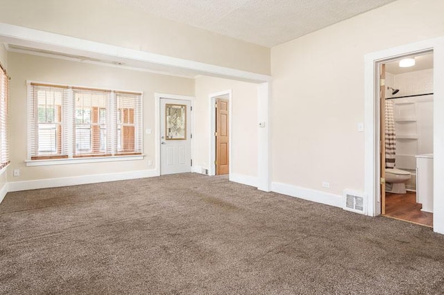 619 Middle St, Beloit, WI 53511 - unfurnished bedroom featuring carpet, connected bathroom, and a textured ceiling