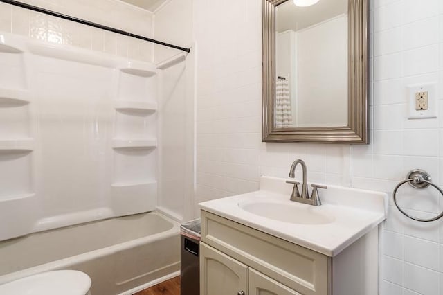 619 Middle St, Beloit, WI 53511 - full bathroom featuring vanity, tile walls, bathtub / shower combination, wood finished floors, and backsplash