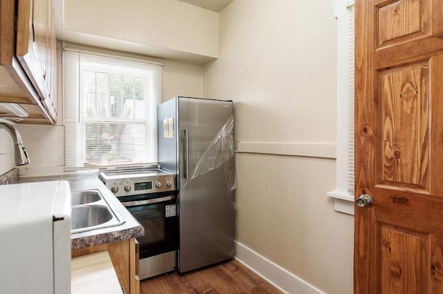 619 Middle St, Beloit, WI 53511 - kitchen with appliances with stainless steel finishes, dark wood-type flooring, tasteful backsplash, and brown cabinetry