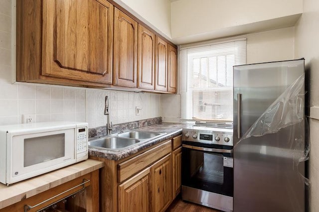 619 Middle St, Beloit, WI 53511 - kitchen featuring stainless steel appliances, brown cabinets, and tasteful backsplash