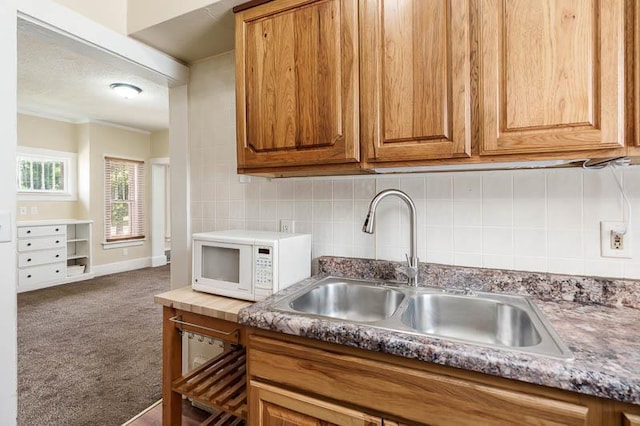 619 Middle St, Beloit, WI 53511 - kitchen featuring white microwave, carpet floors, brown cabinets, and backsplash