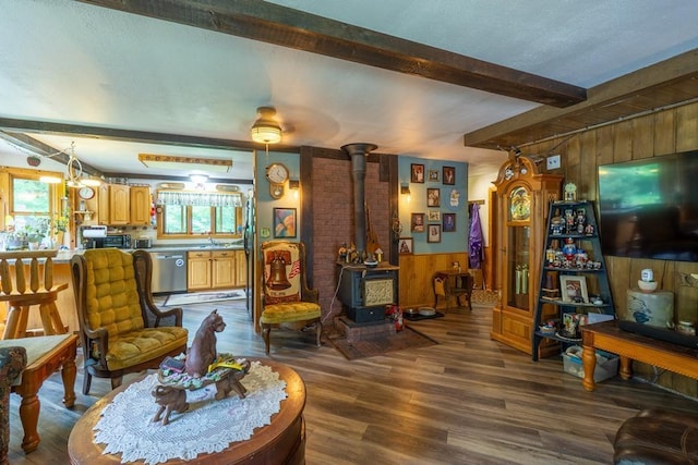 N8981 W Island Rd, Phillips, WI 54555 - living room with a wood stove, wood walls, beamed ceiling, dark wood finished floors, and wainscoting