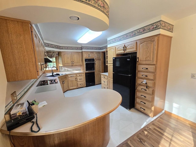 1440 4th St, Port Edwards, WI 54469 - kitchen featuring black appliances, light countertops, a peninsula, under cabinet range hood, and light brown cabinets