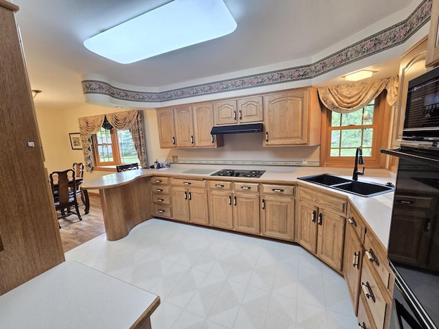 1440 4th St, Port Edwards, WI 54469 - kitchen featuring light countertops, under cabinet range hood, black stovetop, and a peninsula