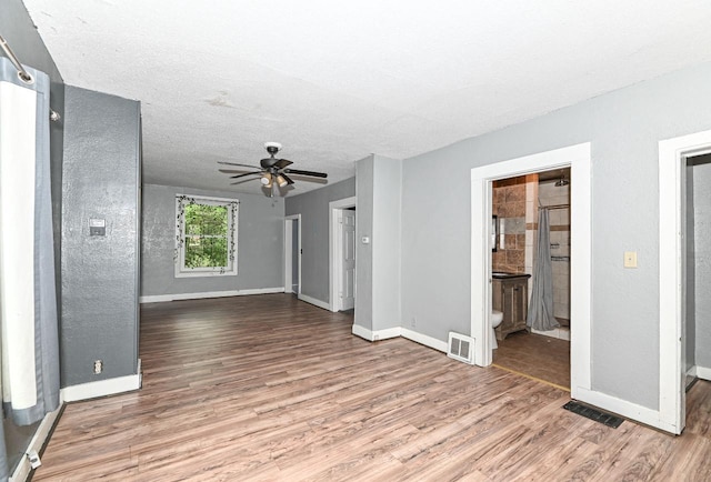 1721 Spring Pl, Racine, WI 53404 - unfurnished living room with wood finished floors, ceiling fan, and a textured ceiling
