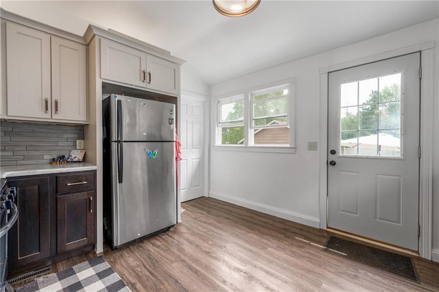 508 Evergreen St, Colfax, WI 54730 - kitchen featuring stainless steel appliances, light wood-type flooring, light countertops, decorative backsplash, and vaulted ceiling