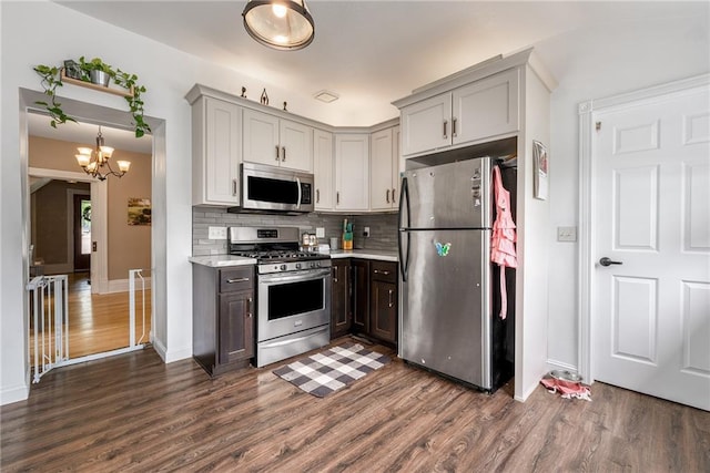 508 Evergreen St, Colfax, WI 54730 - kitchen featuring appliances with stainless steel finishes, dark wood-style flooring, backsplash, a chandelier, and gray cabinets