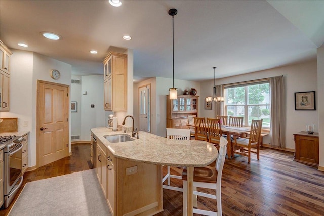 8201 Highview Dr, Madison, WI 53719 - kitchen featuring stainless steel gas range oven, a breakfast bar area, dark wood-style floors, glass insert cabinets, and recessed lighting