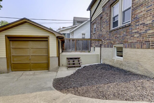 518 Maple Ave, Madison, WI 53704 - view of side of property featuring concrete driveway, a garage, brick siding, and an outdoor structure