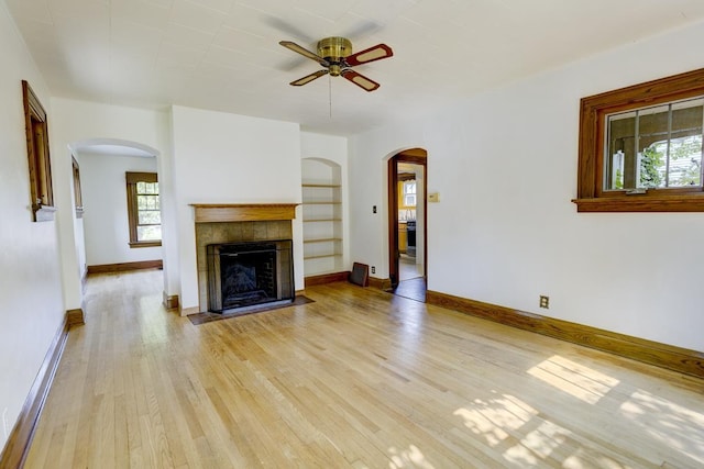 518 Maple Ave, Madison, WI 53704 - unfurnished living room featuring ceiling fan, plenty of natural light, arched walkways, and light wood-style floors