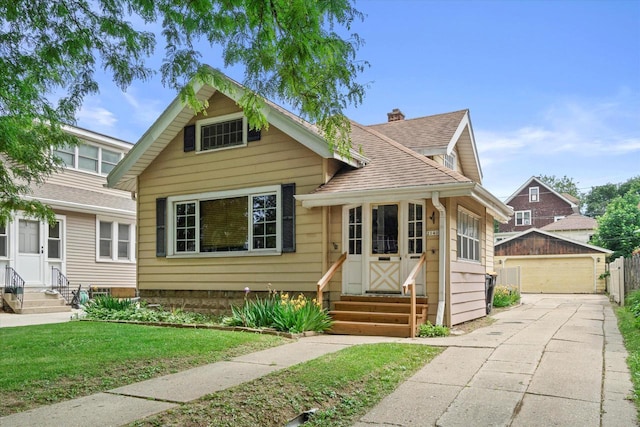 2140 N 64th St, Wauwatosa, WI 53213 - bungalow featuring entry steps, an outbuilding, a garage, a shingled roof, and a front yard