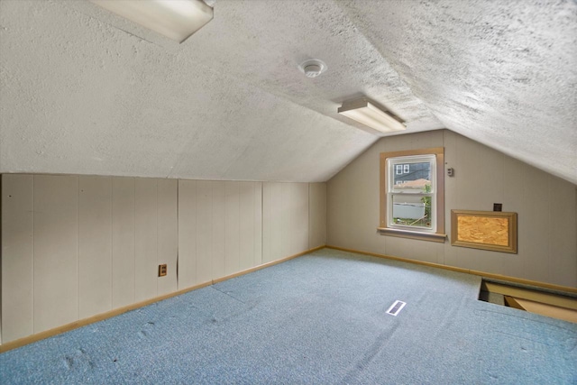 2140 N 64th St, Wauwatosa, WI 53213 - additional living space with vaulted ceiling, a textured ceiling, and carpet flooring
