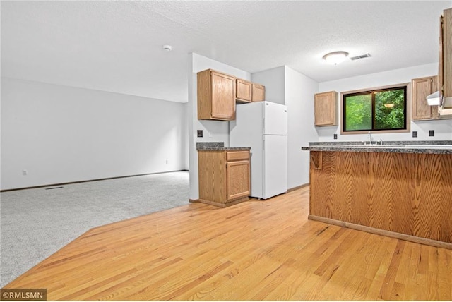 1754 Helena Rd, Oakdale, MN 55128 - kitchen featuring freestanding refrigerator, open floor plan, light wood-style flooring, brown cabinets, and ventilation hood