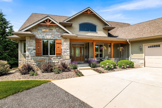 14595 Louis Corners Rd, Kiel, WI 53042 - craftsman inspired home featuring stone siding, a porch, a shingled roof, a garage, and concrete driveway