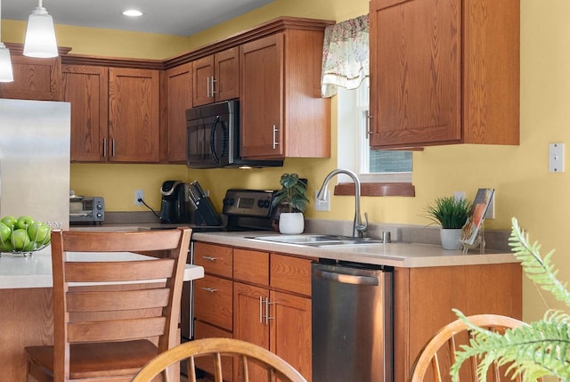 525 Hercules Trl, Madison, WI 53718 - kitchen with appliances with stainless steel finishes, brown cabinetry, light countertops, pendant lighting, and recessed lighting
