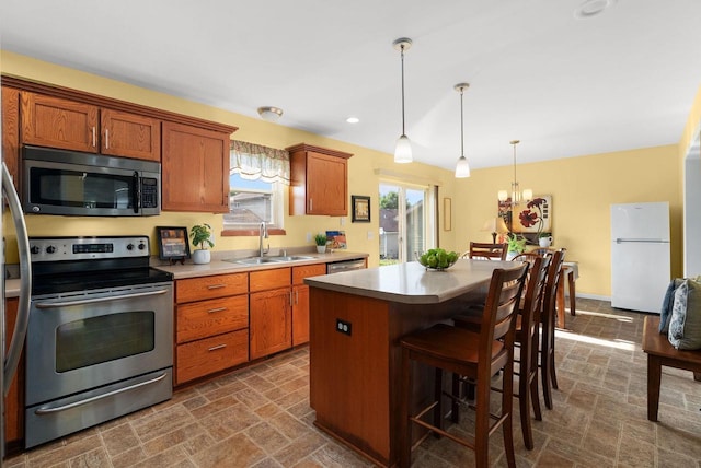 525 Hercules Trl, Madison, WI 53718 - kitchen with appliances with stainless steel finishes, brown cabinetry, light countertops, a center island, and a breakfast bar
